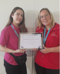 Two St Albans staff members holding a certificate
